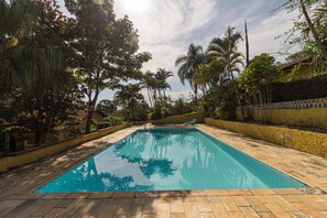 Una piscina al aire libre, tumbonas
