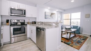 Una cocina moderna con armarios blancos, electrodomésticos de acero inoxidable y encimera de mármol.