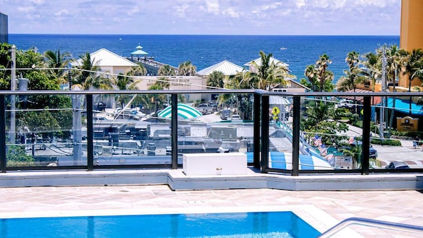 Zona de piscina con vista despejada al océano y ambiente de resort.