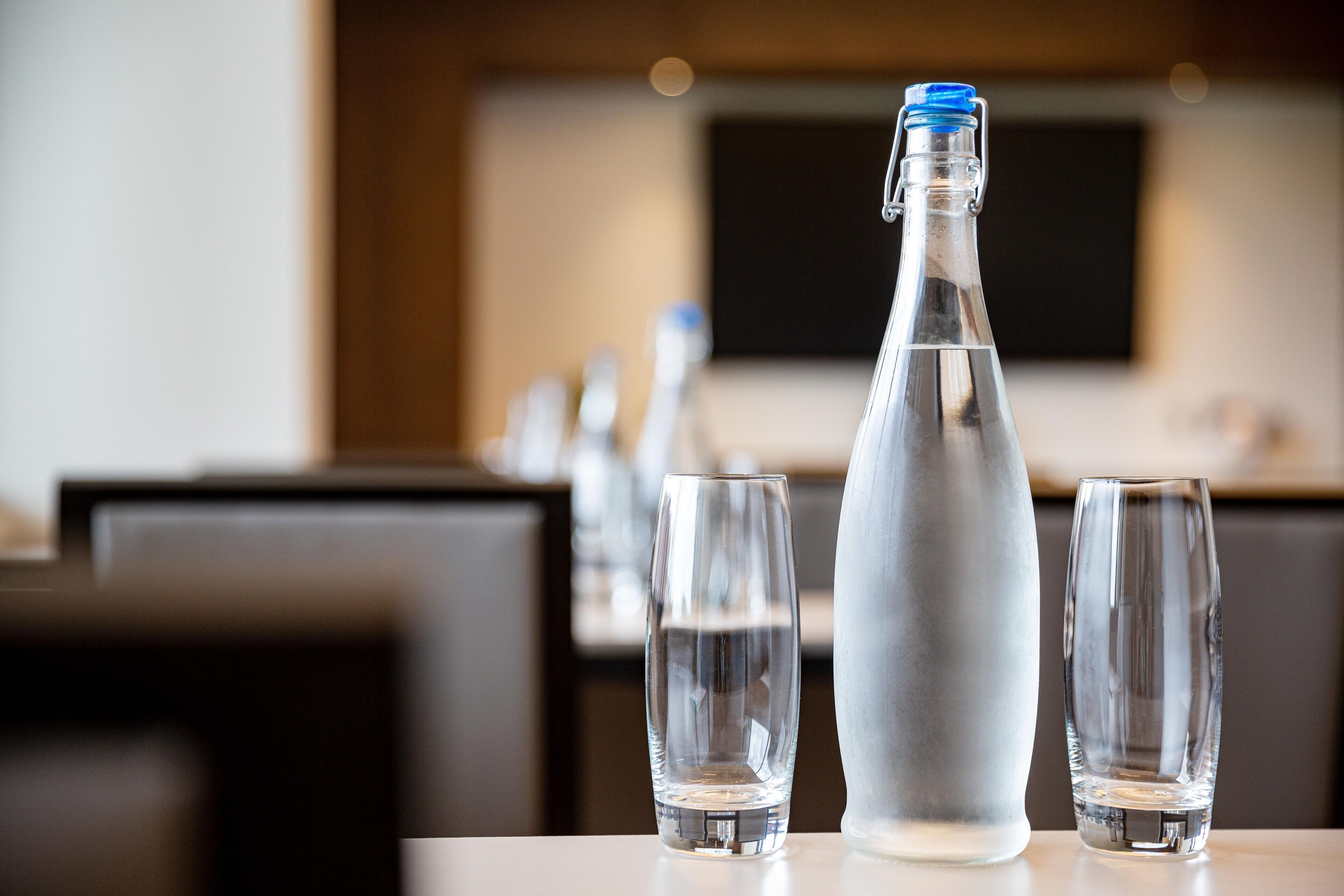 A table with a bottle and two glasses, likely in a dining area.