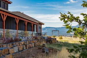 A lodge with a stone foundation, wooden beams, and a view of mountains.