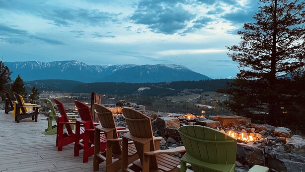 A deck with Adirondack chairs overlooking a mountainous landscape with a fire pit. - Headwaters Lodge at Eagle Ranch Resort (Invermere)