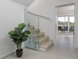A modern staircase with glass railings and a potted plant. - Beautiful private villa for 10 guests with private pool, A/C, WIFI, TV, terrace and panoramic view (Poreč)