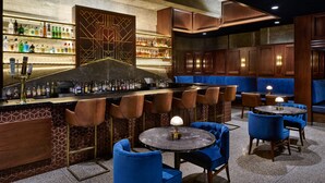 Un espace bar avec un comptoir, des tabourets et des sièges.