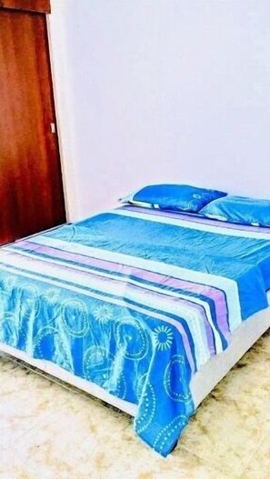 Rest in comfort on this inviting bed, complete with a geometric-patterned bedspread.