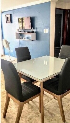 Enjoy meals in this cozy dining area with a glass table and comfortable seating for four.