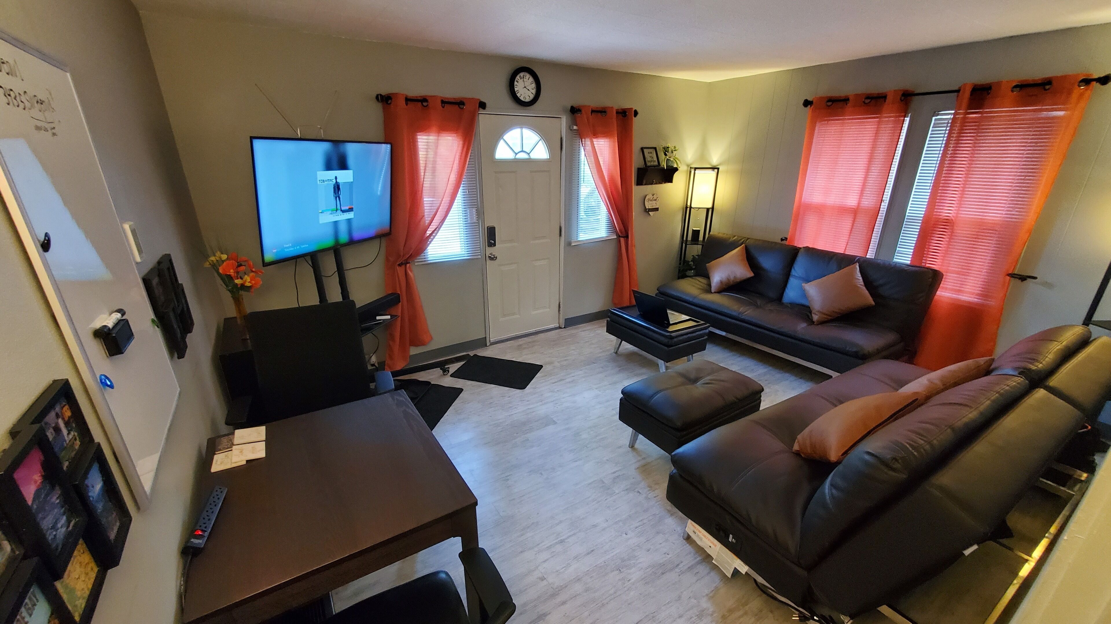 Una sala de estar con sofá, televisor, una mesa de centro y una mesa de comedor.