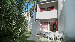 Ein zweistöckiges Gebäude mit Balkon, weißen Wänden und roten Akzenten.
