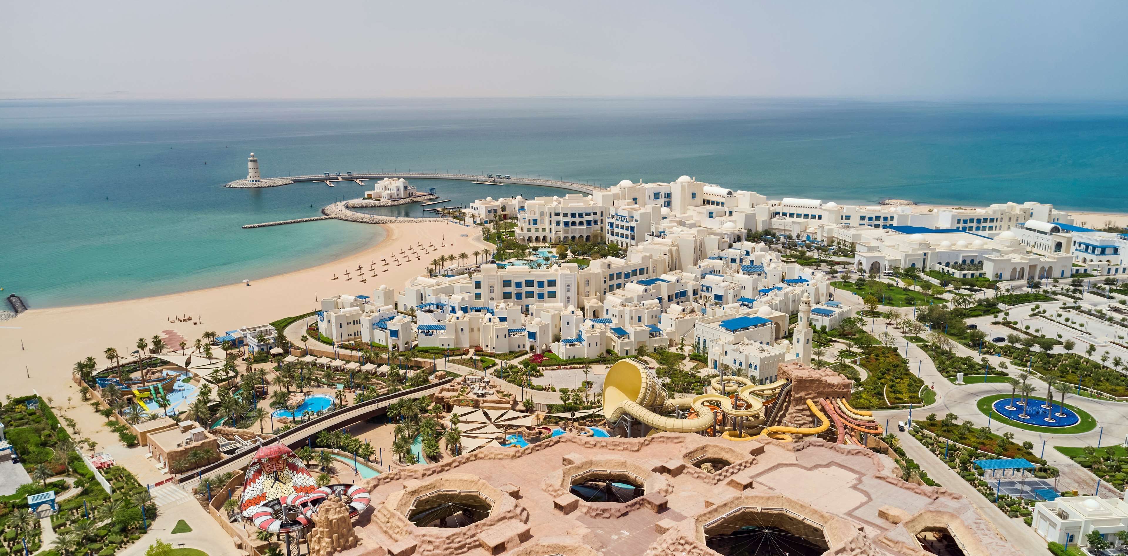 Un complexe hôtelier doté d’une plage, d’un parc aquatique et de plusieurs bâtiments offrant une vue sur la mer.