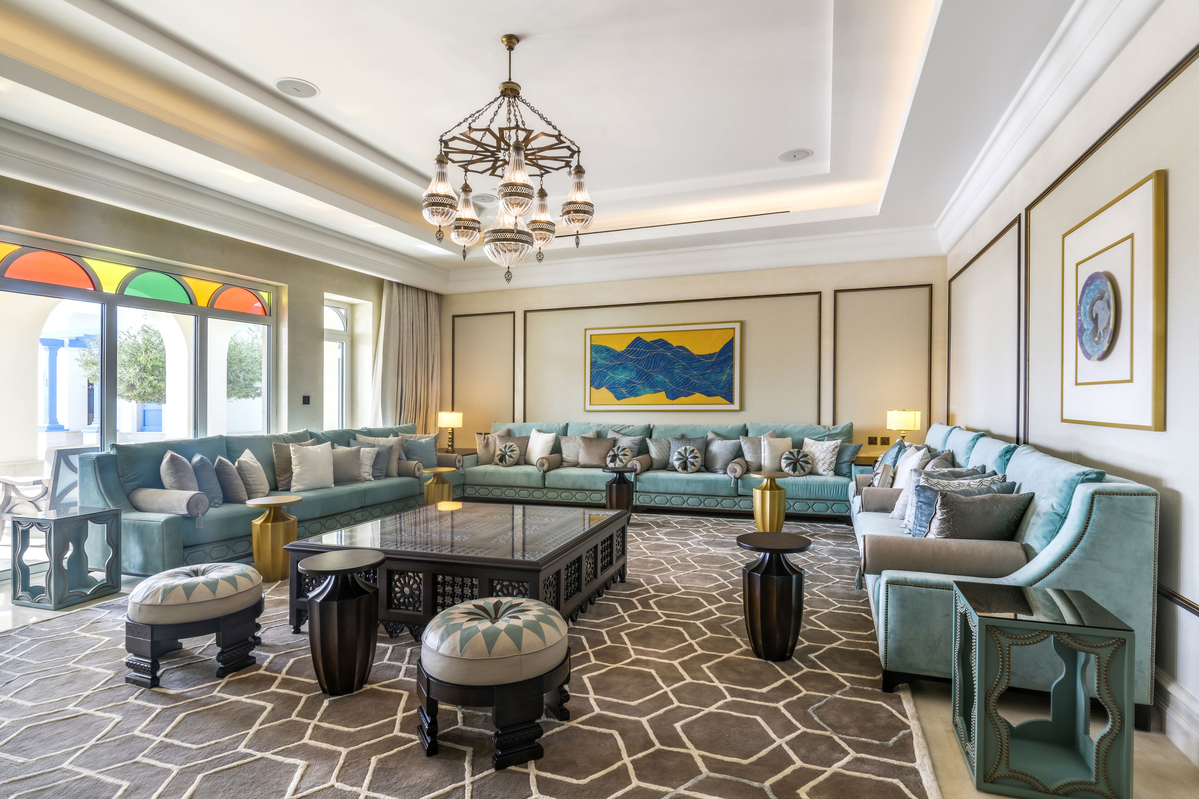 A spacious living room with a sectional sofa, a coffee table, and a chandelier.