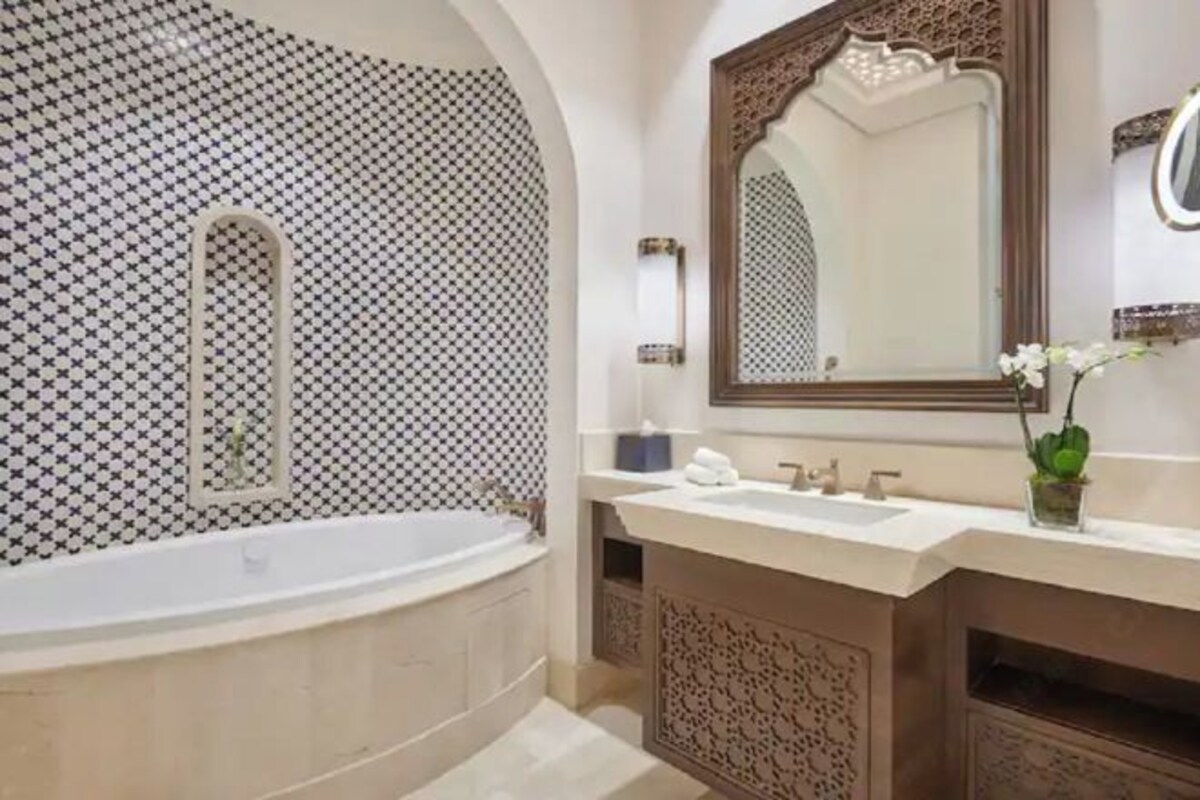 Une salle de bain avec une baignoire, un lavabo et un miroir.