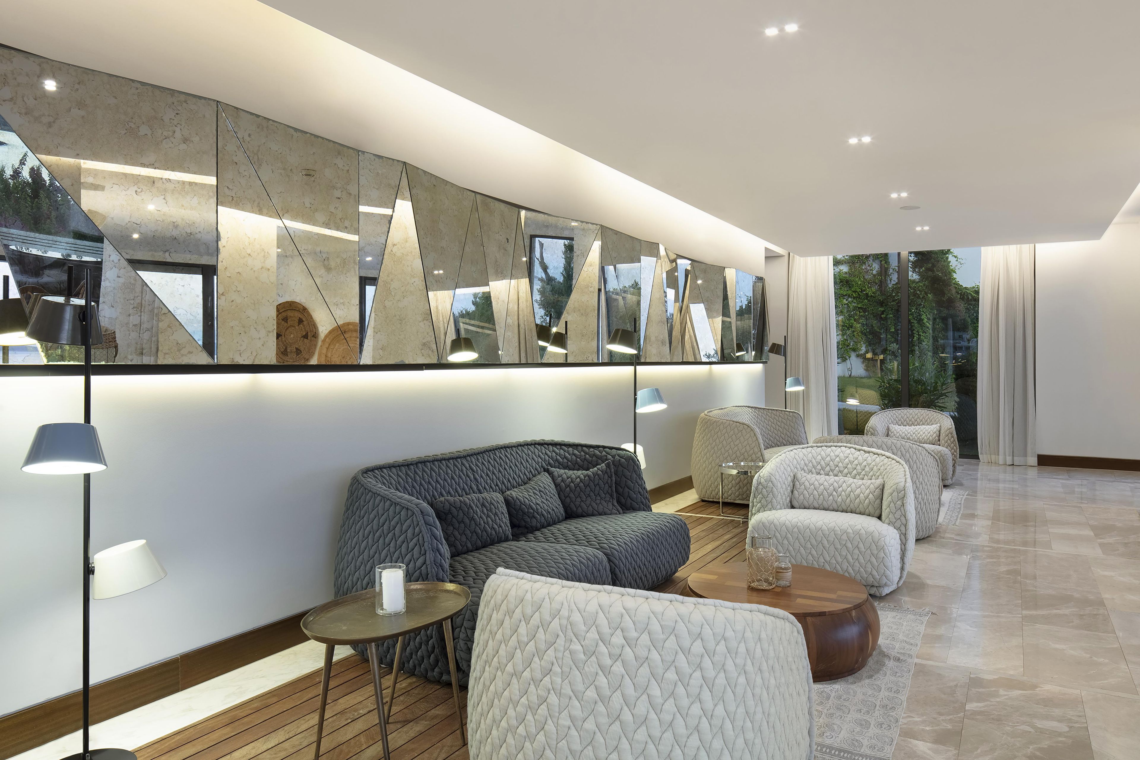 Un interior moderno con un sofá, sillones y una mesa de centro.