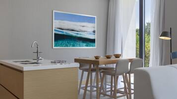 Una cocina moderna con encimera blanca, pileta de acero inoxidable y armarios de madera.