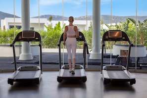 A gym with treadmills and a person using one.