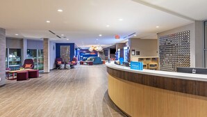A modern hotel lobby with a reception desk, seating area, and a decorative wall. - Tru by Hilton Laredo Airport (Laredo)