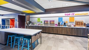 A modern breakfast area with a counter, stools, and various food items. - Tru by Hilton Laredo Airport (Laredo)