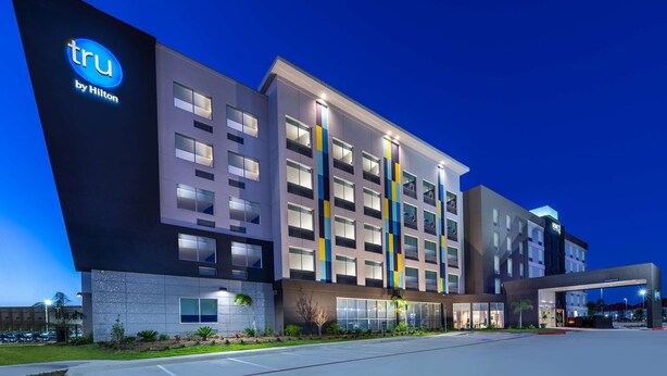 A modern hotel building with a prominent 'tru by Hilton' sign, multiple floors, and a well-lit entrance. - Tru by Hilton Laredo Airport (Laredo)