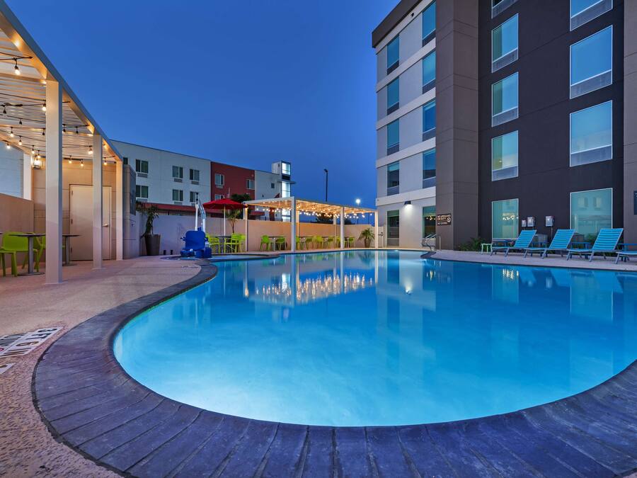 A swimming pool with lounge chairs and a covered seating area.