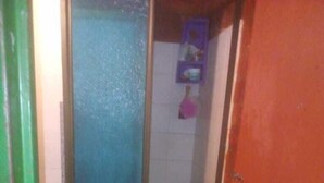 A bathroom with a toilet, a sink, and a shower stall. - Casa Wilber (Cali)