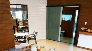 Un bufé de desayuno con diversas frutas, pasteles y bebidas sobre una mesa de madera en una cocina moderna.