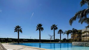 A swimming pool with lounge chairs, palm trees, and a clear sky. - Sunset at Vila da Praia - Neat to Alvor Beach and Very Close to Alvor Village (Alvor)