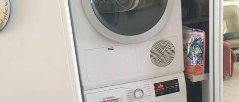 A stacked washer and dryer unit with a Bosch logo, a digital display, and a control panel.