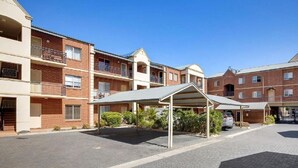 A multi-story residential building with a covered parking area and a paved walkway. - Prime Location | North Adelaide 2BR Apt, Melbourne St | Courtyard |Near CBD Events + Private Parking (North Adelaide)