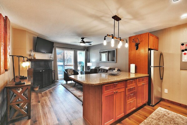 A kitchen with wooden cabinets, a granite countertop, a built-in refrigerator, and a ceiling fan. - Mountain Views! Hot Tub/Pool Walk to Lifts & Main1 (Park City)
