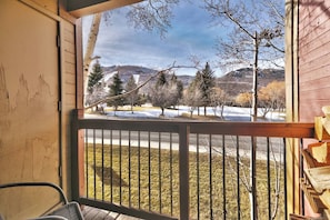 A balcony with a view of a snowy landscape, a wooden railing, and a chair. - Mountain Views! Hot Tub/Pool Walk to Lifts & Main1 (Park City)