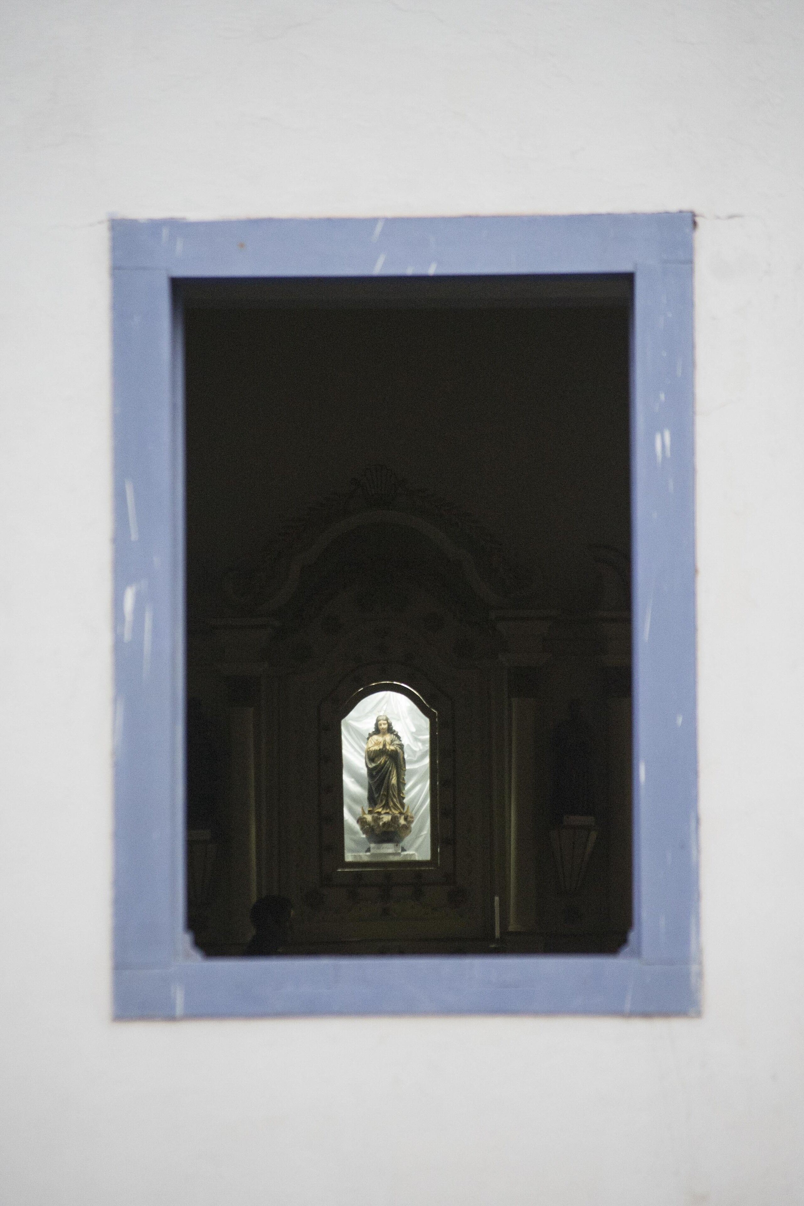 A framed window with a statue inside.