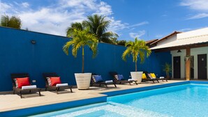 A swimming pool with lounge chairs and palm trees. - Coqueiros Praia Hotel - Balneário de Iriri (Anchieta)