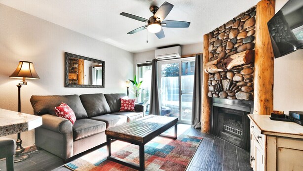 A cozy living room with a sofa, coffee table, and fireplace.