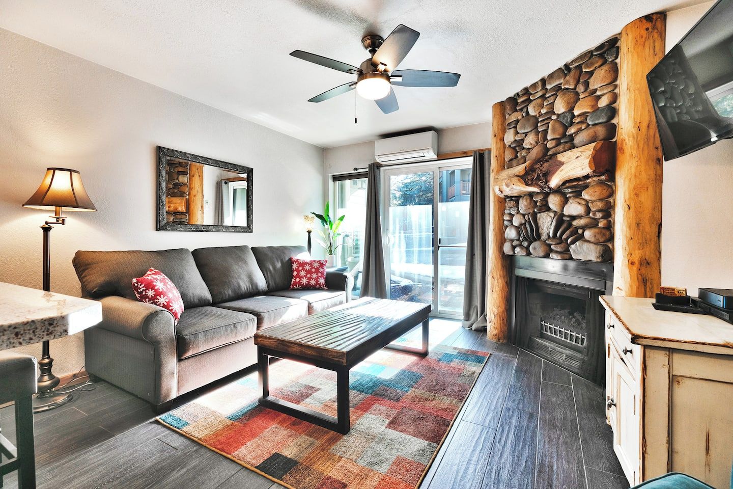 A living room with a sofa, coffee table, and a fireplace.