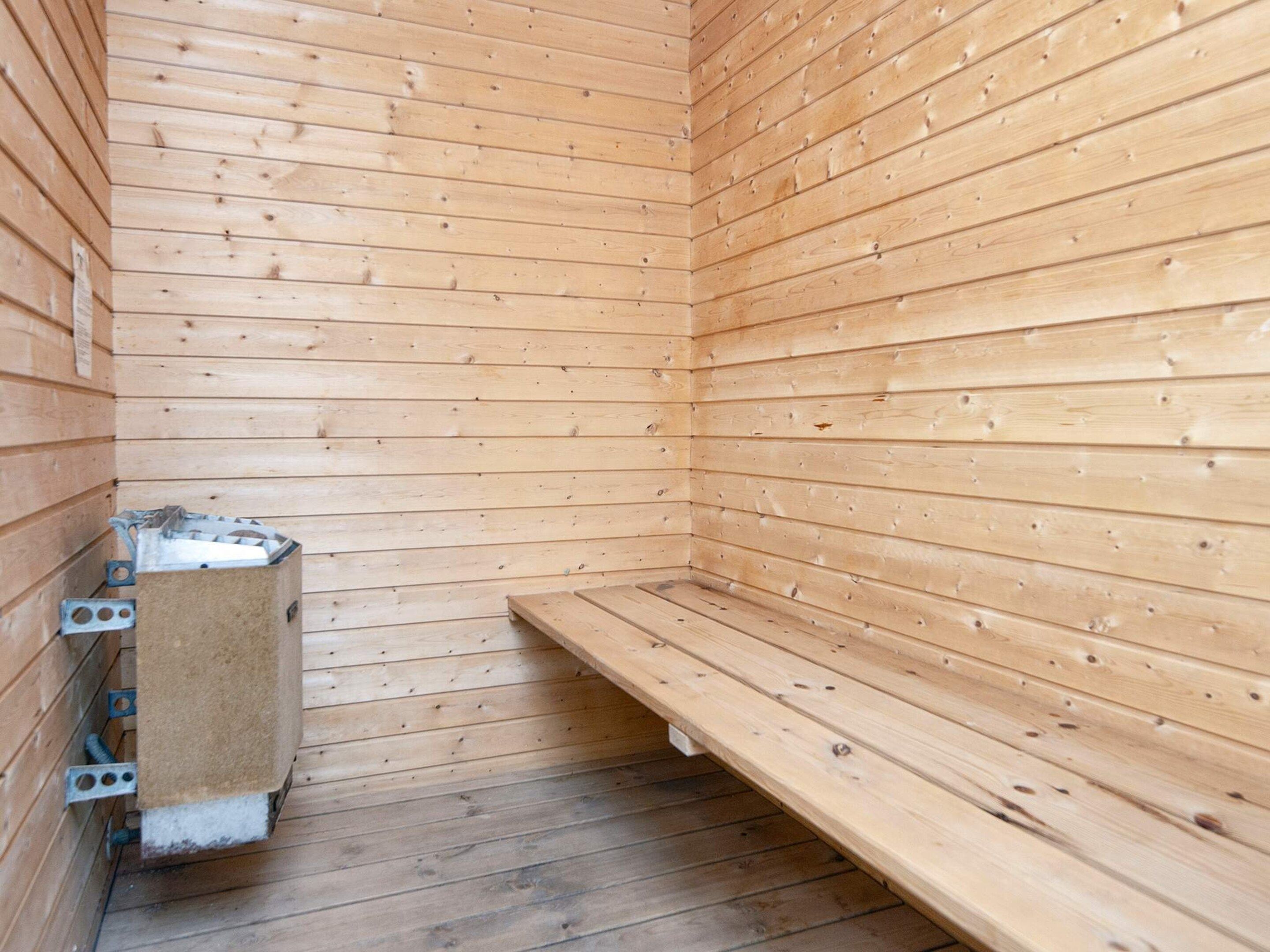 Un sauna con paredes de madera y un banco.