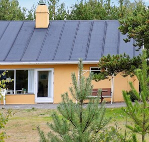 A two-story building with a dark roof and a yellow facade. There is a sign indicating it is a DanCenter Preferred location. - 7 Person Holiday Home in Jerup (Strandby)