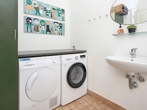 A laundry area with two Bosch washing machines, a sink, and a mirror above it. - 4 Star Holiday Home in Harboore (Harboore)