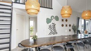 A modern dining area with a wooden table, grey chairs, and woven pendant lights. - 4 Star Holiday Home in Harboore (Harboore)