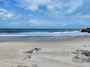 A beach with waves, a clear sky, and rocky outcrops. - 5 Star Holiday Home in Laeso (Læsø)