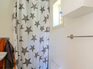 Bathroom features a shower curtain with a star pattern, a towel rack, and a radiator.