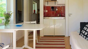 A compact living space with a dining area, kitchenette, and a bed. - 4 Person Holiday Home in Axvall (Axvall)