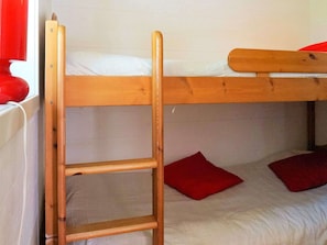 A bunk bed with a wooden ladder, a window with a red curtain, and a white wall. - 4 Person Holiday Home in Axvall (Axvall)