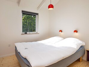 A bedroom with a bed, a window, and two wall-mounted lights. - 4 Star Holiday Home in Lokken (Lokken)