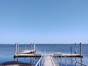 Une jetée s’avançant dans une eau calme, sous un ciel dégagé.