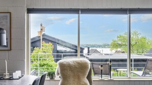 A room with a large window, a dining table with chairs, and a fluffy chair. - 4 Star Holiday Home in Hejls (Hejls)
