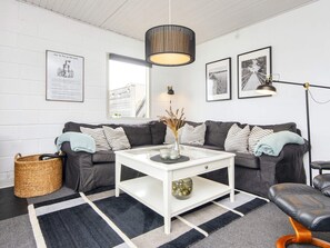 A modern living room with a sofa, coffee table, and a lamp. - 4 Star Holiday Home in Hejls (Hejls)