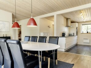 A modern kitchen with a dining area, wooden ceiling, and pendant lights. - 5 Star Holiday Home in Hadsund (Hadsund)
