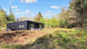 A modern cabin with a large deck area, surrounded by a forested landscape. - 5 Star Holiday Home in Hadsund (Hadsund)