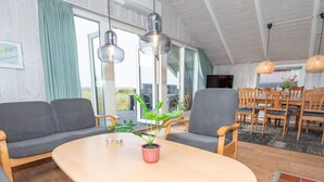 A modern living room with a wooden table, two grey sofas, and a potted plant. - 6 Person Holiday Home in Harboore (Harboore)