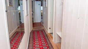 A hallway with a red patterned carpet, white walls, and a glass door leading to another room. - 6 Person Holiday Home in Harboore (Harboore)