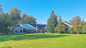 A large, modern house with a spacious lawn, a garage, and a covered outdoor area. - 8 Person Holiday Home in Hemmet (Hemmet)